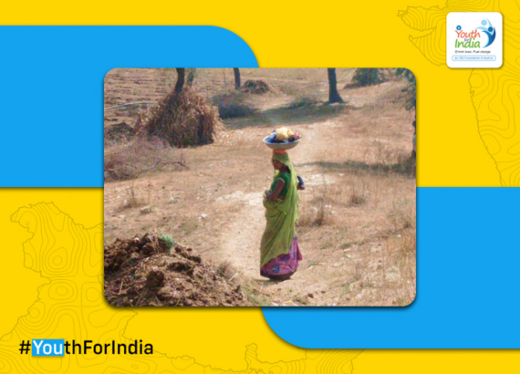 A pregnant woman carrying clothes to clean in a nearby stream